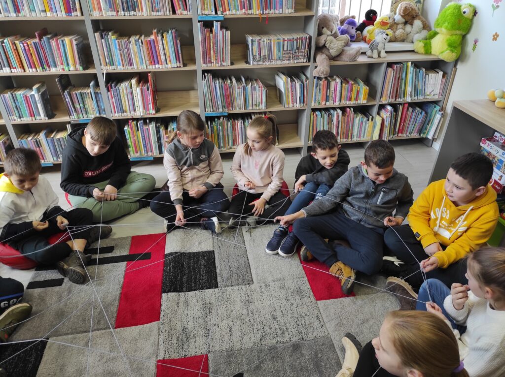 Dzieci siedzą na podłodze w bibliotece